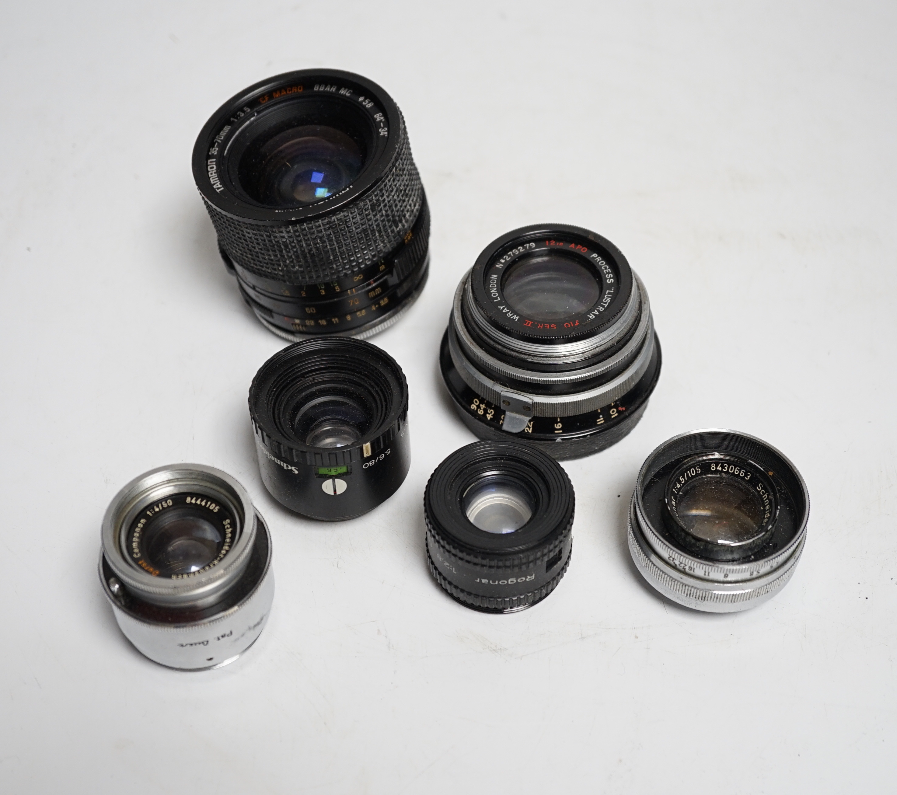 A collection of lenses for still cameras, including examples by Schneider-Kreuznach, Wray, Aldis, Tamron, etc.